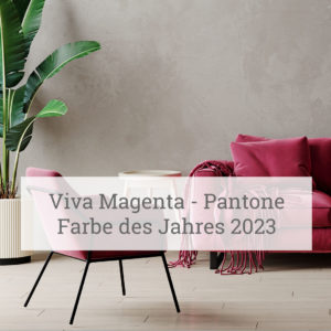 Ein modernes Interieur mit einem runden Tisch mit in der Mitte, begleitet von einem Stuhl in der Farbe Magenta. Ein magentafarbenes Sofa mit einer über eine Seite drapierten Decke ist sichtbar. Hinter den Möbeln steht links eine Topfpflanze vor einer strukturierten grauen Wand. Der Text im Bild lautet ‘Viva Magenta - Pantone Farbe des Jahres 2023’.